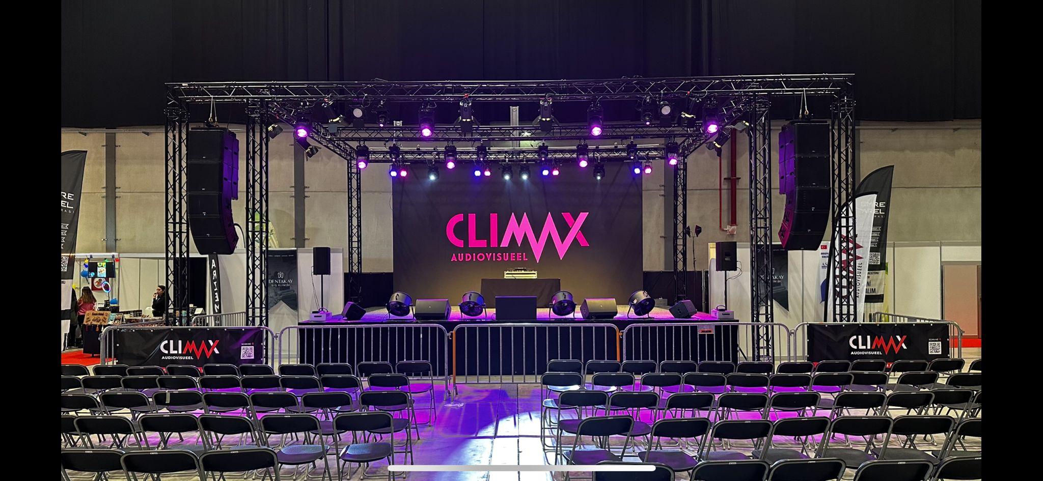 Gebrandete Messebühne mit großer CLIMAX-LED-Rückwand und violettem Licht