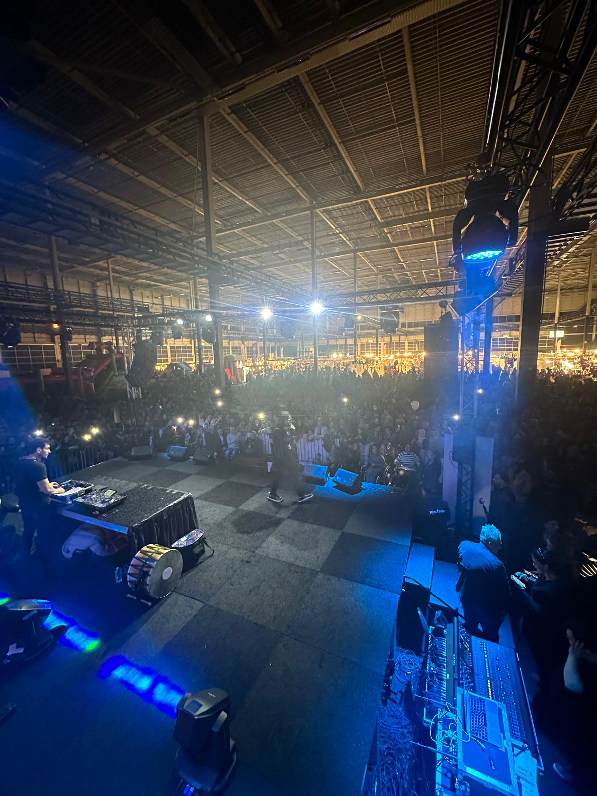 Große Open-Air-Festivalbühne bei Dämmerung mit Bühnenlicht und LED-Screens